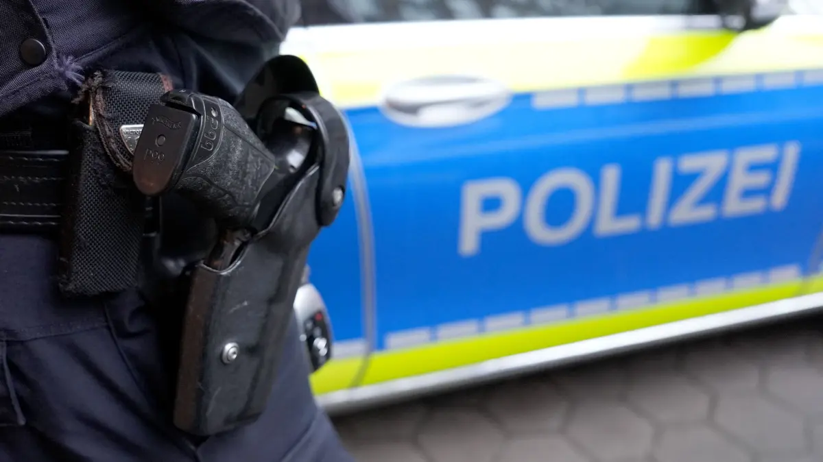 Ein Polizist steht vor einem Einsatzfahrzeug der Polizei. In Waldachtal-Tumlingen kam es zu einem größeren Einsatz des Landeskriminalamts. (Symbolbild)