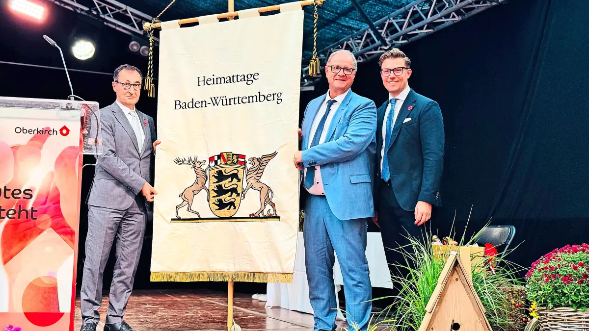 Ministerpräsident Cem Özdemir (links) übergab die Heimattagefahne feierlich bei den Landesfesttagen in Oberkirch an Oberbürgermeister Jürgen Roth (Mitte). Gregor Bühler, Oberbürgermeister von Oberkirch (rechts), gibt den Staffelstab damit an die Stadt Villingen- Schwenningen weiter.