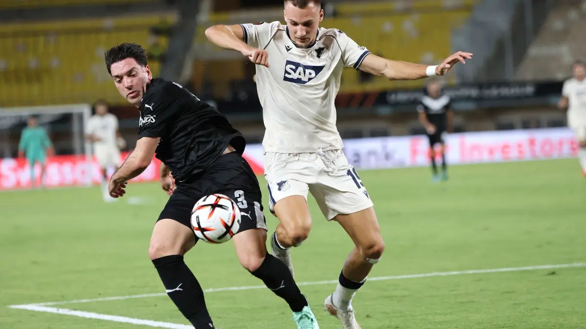 OFI Kreta - TSG 1899 Hoffenheim: 17.09.2026, Griechenland, Kreta: Fußball, Männer: Europa League, OFI Kreta - TSG 1899 Hoffenheim, Vorrunde, 1. Spieltag. Nikos Athanasiou von OFI (l) kämpft mit Tim Lemperle von Hoffenheim um den Ball. Foto: InTime Sports/InTime Sports/AP/dpa +++ dpa-Bildfunk +++