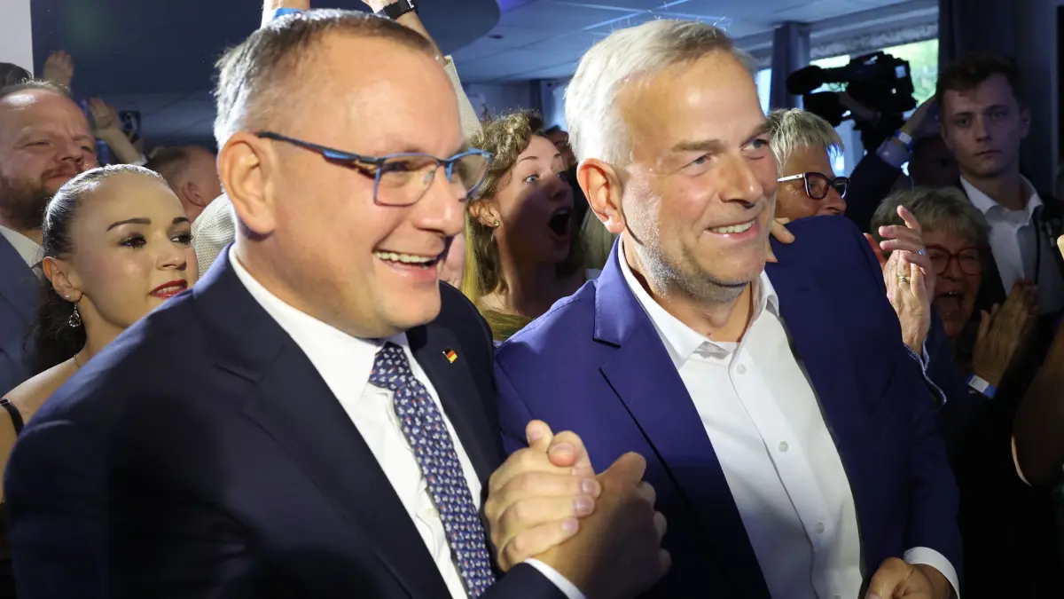 Landtagswahl Mecklenburg-Vorpommern - Wahlparty AfD: 20.09.2026, Mecklenburg-Vorpommern, Schwerin: Leif-Erik Holm (AfD, r), Ministerpräsidentenkandidat der AfD und Direktkandidat im Wahlkreis Schwerin, und Tino Chrupalla (vorne l), AfD-Bundesvorsitzender, reagieren auf der Wahlparty seiner Partei in der Eventlocation Seeterasse auf die Prognose zur Landtagswahl. Die Landtagswahl in Mecklenburg-Vorpommern fand am Sonntag (20.09.2026) statt. Foto: Jens Büttner/dpa +++ dpa-Bildfunk +++