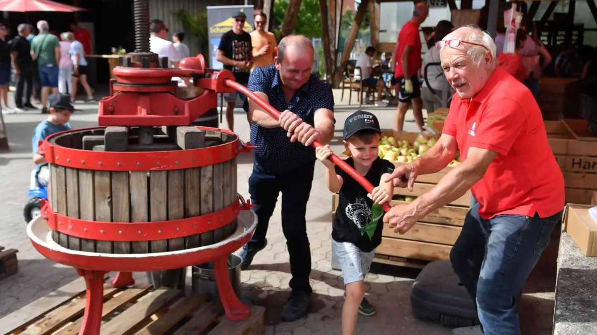 Hans Mild (rechts) stellte „s’Milde“ Obsthof in Dundenheim gemeinsam mit den Besuchern Apfelsaft her