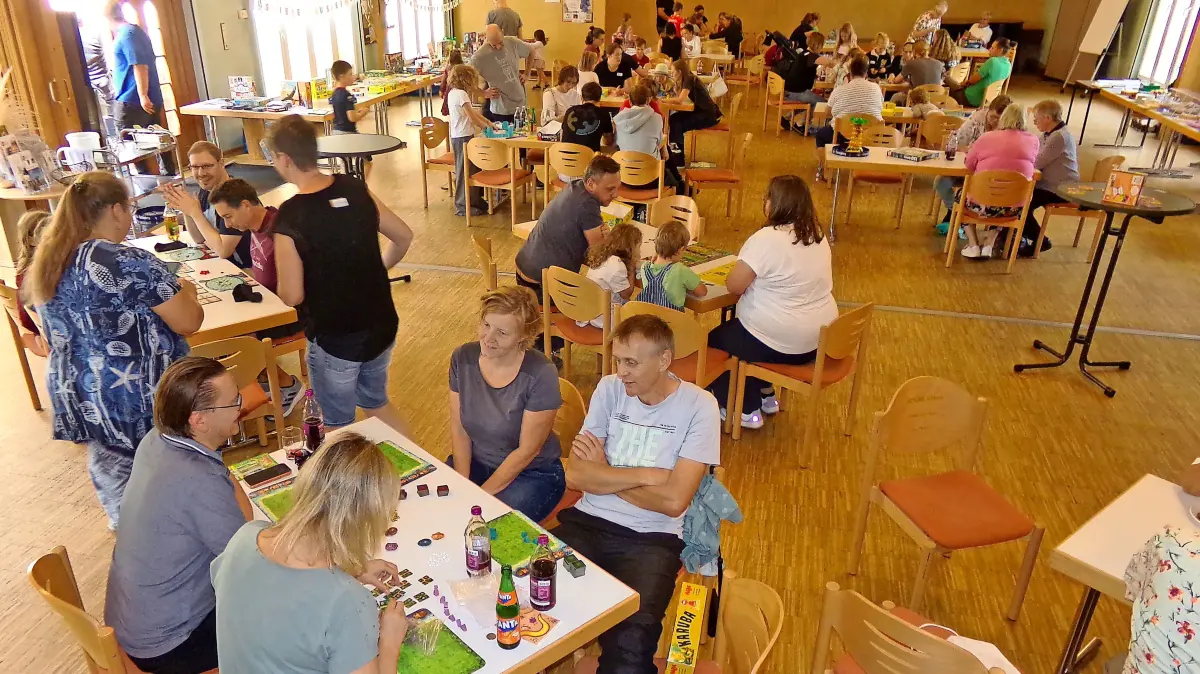 Der Donaueschinger Mariensaal verwandelt sich in ein lebendiges Spieleparadies. Über 100 Teilnehmer mischen bei dem Brettspielangebot mit.