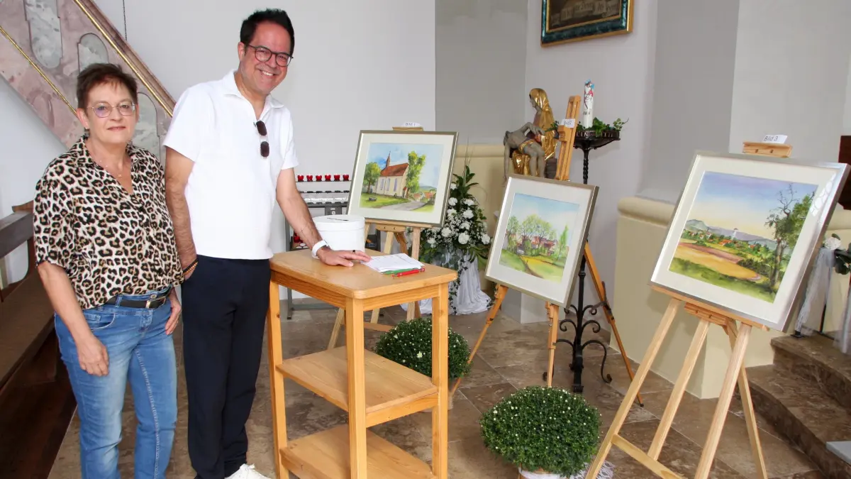 Die Gemeinderätin Manuela Edelmann und der stellvertretende Bürgermeister Markus Gauss schauen sich die drei Aquarelle von Josef Haug an. Die Bilder des Rangendinger Kunstmalers konnte man für den guten Zweck ersteigern.