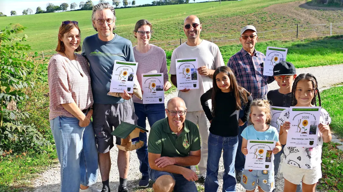 OGV-Vorsitzender Matthias Metzger (kniend) zeichnet die Erstplatzierten Teilnehmer aus und freut sich über die rege Beteiligung am Sonnenblumenwettbewerb.