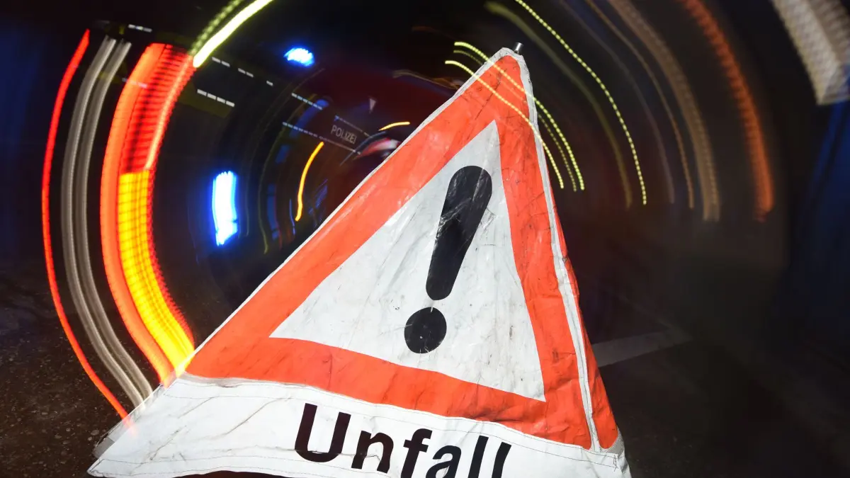 Autounfall: Ein Warndreieck mit dem Schriftzug «Unfall» steht vor einem Blaulicht auf der Straße. (zu dpa: «Mehr Unfälle, aber weniger Verkehrstote im ersten Halbjahr»)