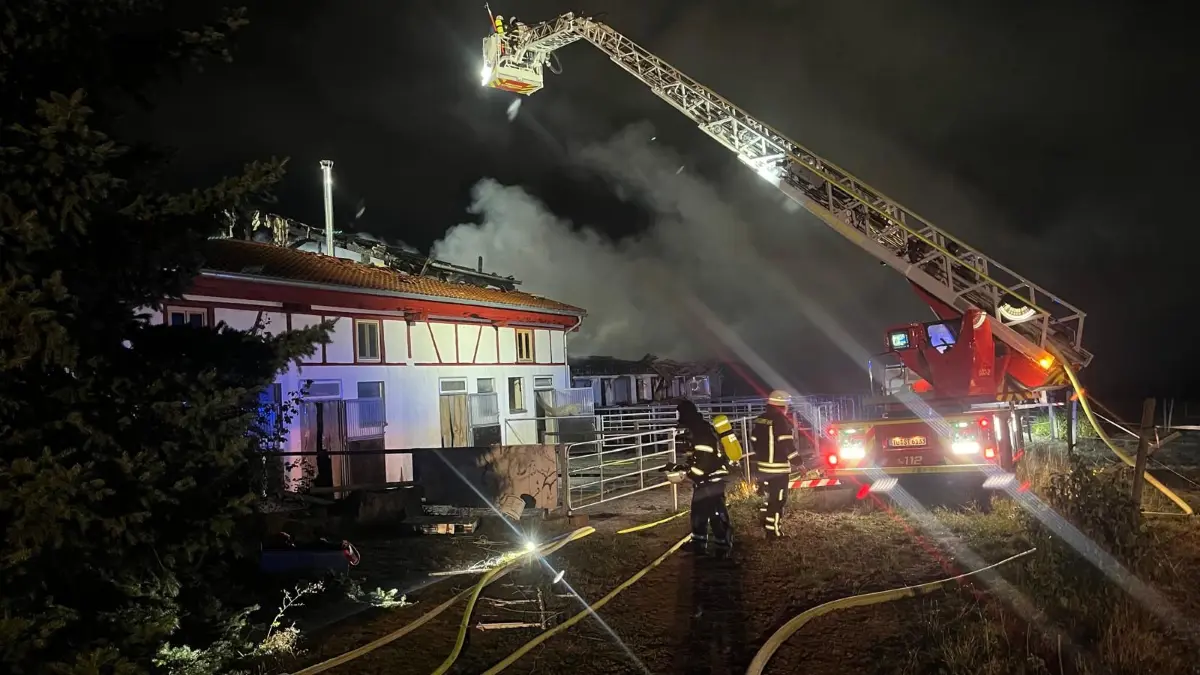 Feuerwehrleute bekämpfen die Flammen auf dem Reiterhof: Das Feuer war offenbar in einer Scheune ausgebrochen und griff dann auf einen Stall über.