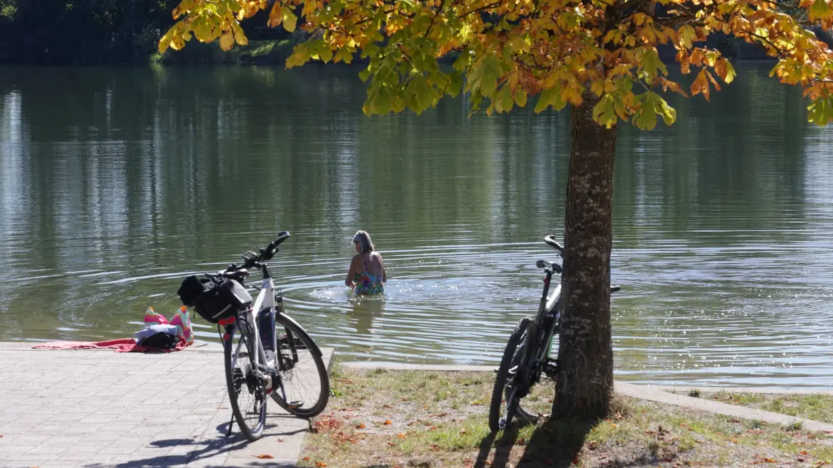 Wetter in Baden-Württemberg: 26.09.2026, Baden-Württemberg, Ertingen: Eine Frau badet im Schwarzachtalsee Foto: Thomas Warnack/dpa +++ dpa-Bildfunk +++