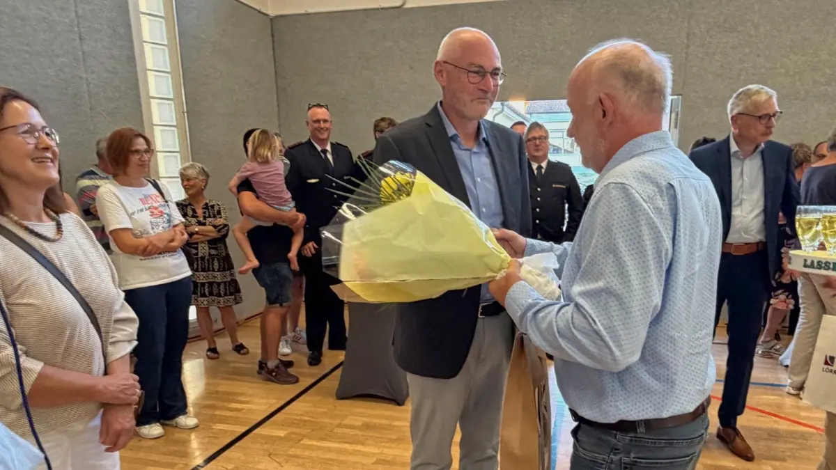 Bürgermeister Axel Moick (rechts) gratuliert seinem Nachfolger Jürgen Walliser mit Blumen in der Hand.