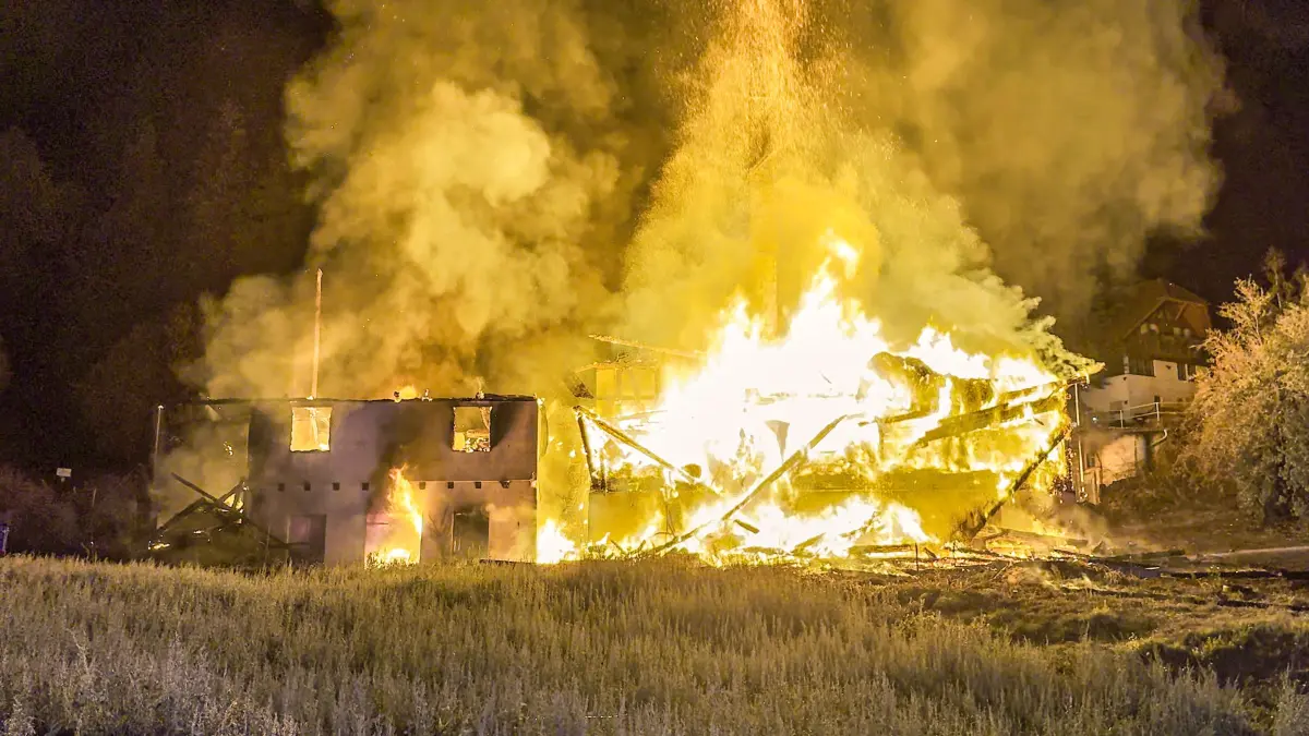 Einsatzkräfte bekämpfen in der Nacht auf Montag einen Großbrand in Gutach (Schwarzwaldbahn) im Ortenaukreis. Ein Bauernhaus steht in voller Ausdehnung in Flammen. Nach Angaben der Polizei griff das Feuer auf angrenzende Gebäude und ein Waldstück über. Zwei Menschen wurden bislang leicht verletzt. Die nahe gelegene Strecke der Schwarzwaldbahn wurde bis auf Weiteres gesperrt. Die Brandursache ist noch unklar.
