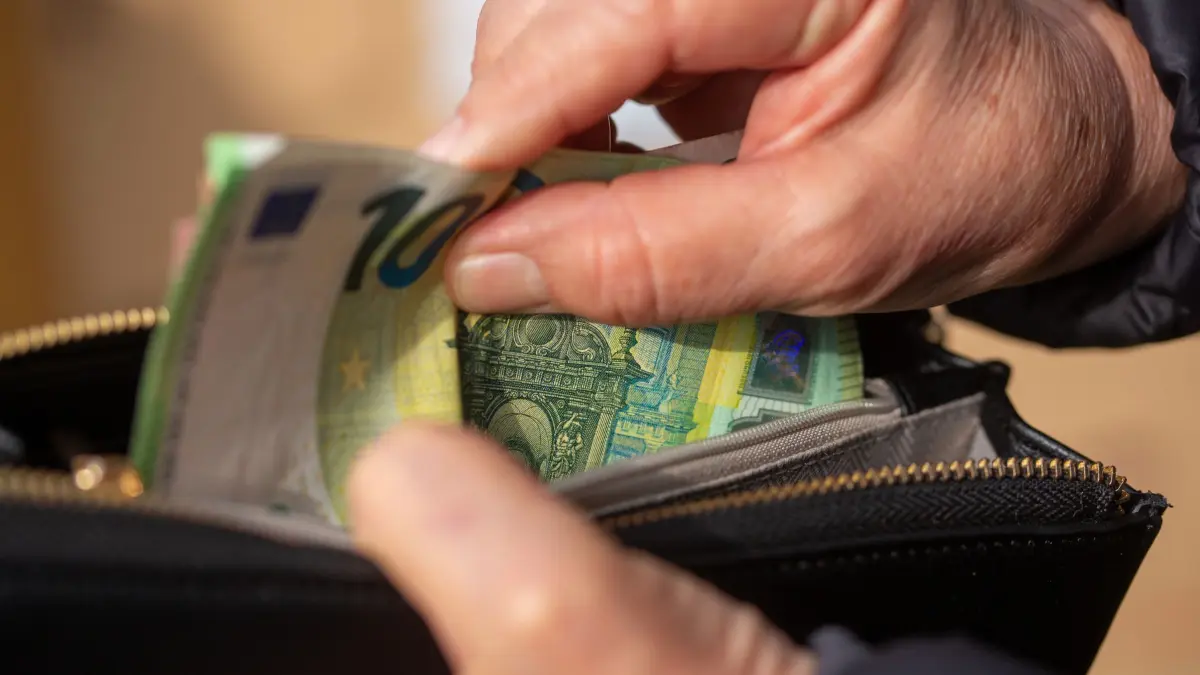 Eine Seniorin steckt Euro-Banknoten in eine Geldbörse: ILLUSTRATION - Keine Zusatzkosten für Bargeld: Pflegeheime dürfen für die Verwahrung von Bar- und Taschengeld grundsätzlich kein gesondertes Entgelt berechnen. Foto: Fernando Gutierrez-Juarez/dpa - Honorarfrei nur für Bezieher des Dienstes dpa-Magazin +++ dpa-Magazin +++