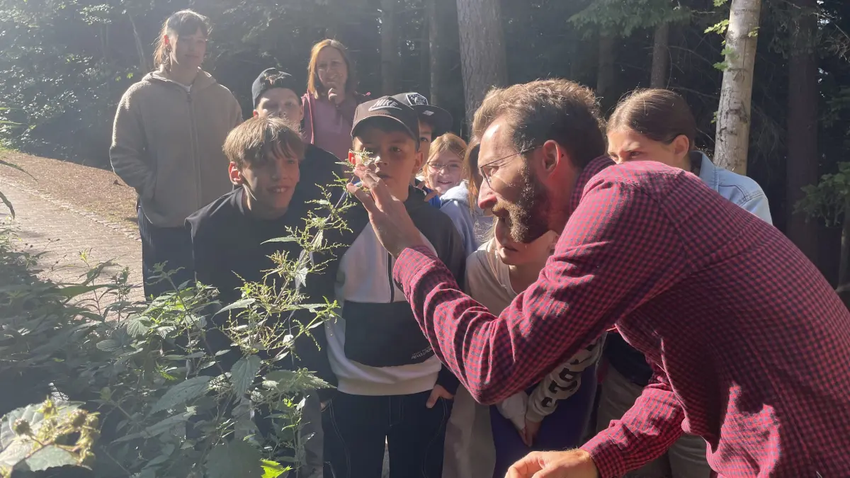 Jan Braun erklärt Schülern der St. Georgener Realschule, wie man Brennnesseln schmerzfrei ernten kann.