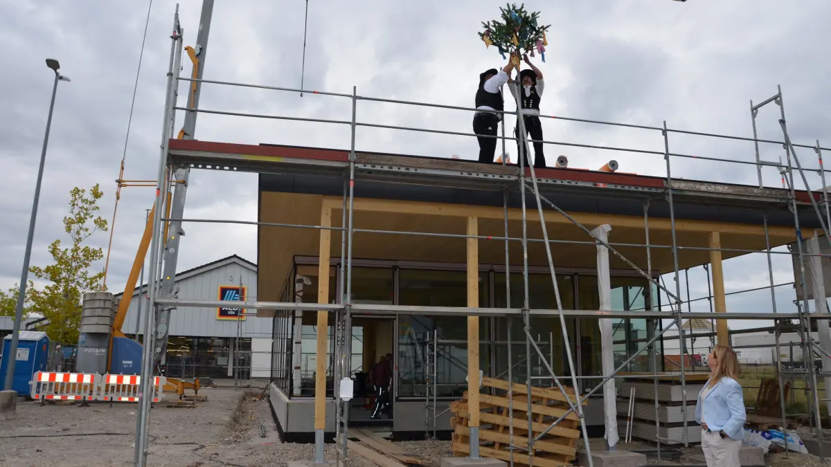 Traditionsgemäß wurde von zwei Zimmerhandwerkern zum Richtfest der passende Richtspruch ausgesprochen und der geschmückte Baum auf dem Flachdach befestigt.