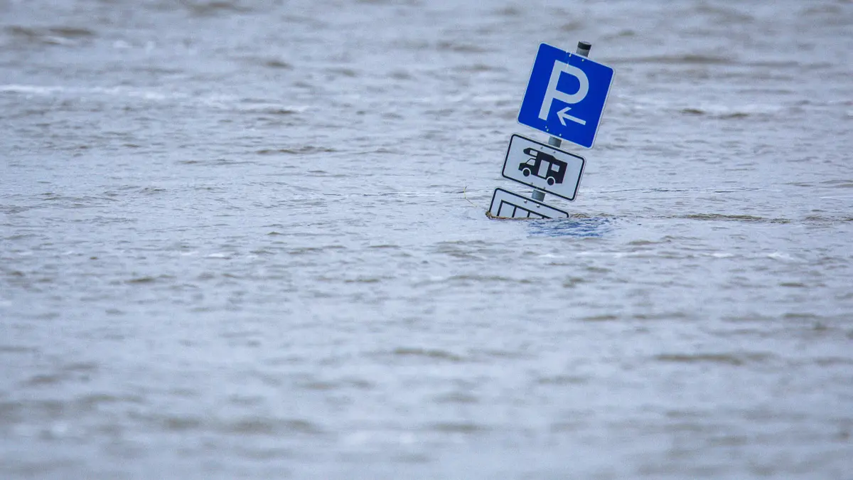 ARCHIV - 04.01.2024, Niedersachsen, Darchau: Das Parkplatzschild für Wohnmobile steht im Hochwasser am Jahresanfang am Fähranleger an der Elbe im Amt Neuhaus. (zu dpa: «Fehlender Hochwasserschutz? Landkreise besorgt») Foto: Jens Büttner/dpa +++ dpa-Bildfunk +++