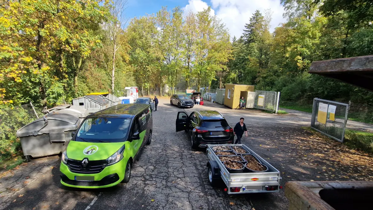 Betriebsamkeit im Waldidyll: Während die Bürger am Freitagmittag ihre Autos und Anhänger entladen, behält Hofleiter Oswald Blum (hinten rechts sitzend) gelassen den Überblick. Geht es nach den Plänen des Landkreises, droht dem Standort das Aus.