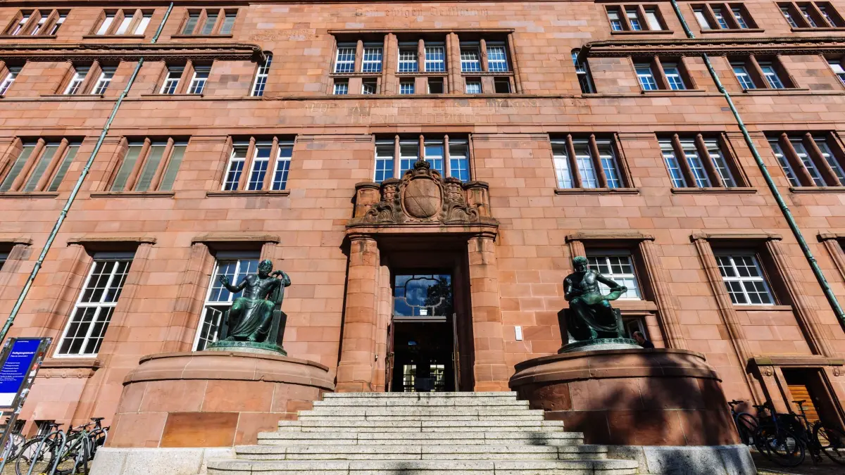 Universität Freiburg: 02.10.2026, Baden-Württemberg, Freiburg im Breisgau: Skulpturen von Homer (l) und Aristoteles rahmen vor dem Haupteingang des Kollegiengebäude I (KG1) der Universität Freiburg ein. Foto: Philipp von Ditfurth/dpa +++ dpa-Bildfunk +++