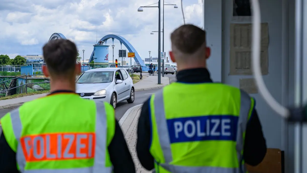 Grenzkontrollen: ARCHIV - 11.06.2026, Brandenburg, Frankfurt (Oder): Zwei Beamte der Bundespolizei stehen am deutsch-polnischen Grenzübergang Stadtbrücke bei der Einreise nach Deutschland. (zu dpa: «Etwas mehr Asylanträge - Langfristiger Abwärtstrend bleibt») Foto: Patrick Pleul/dpa +++ dpa-Bildfunk +++
