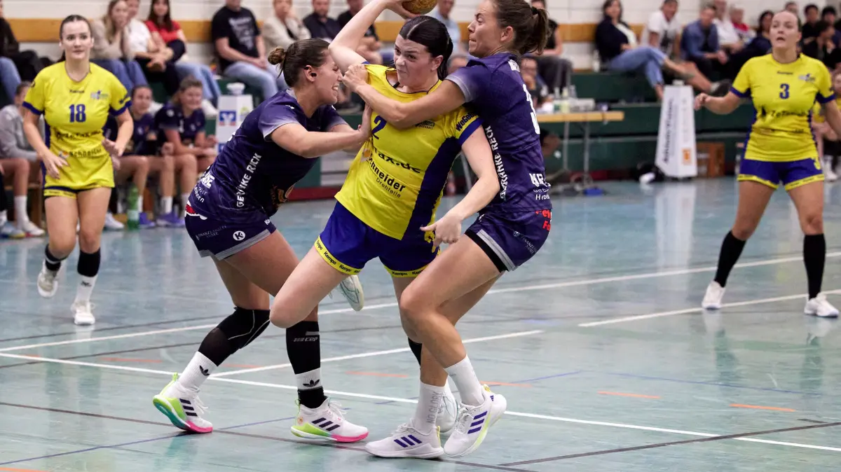 Mia Wöhrle wird von zwei HSG-Spielerinnen in die Mangel genommen