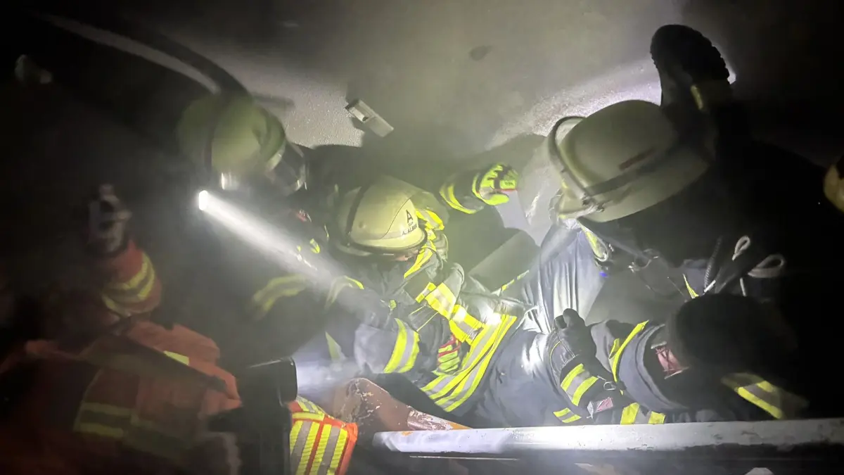 Gemeinsam tragen die Einsatzkräfte der Abteilung Walddorf das Opfer aus dem Haus.