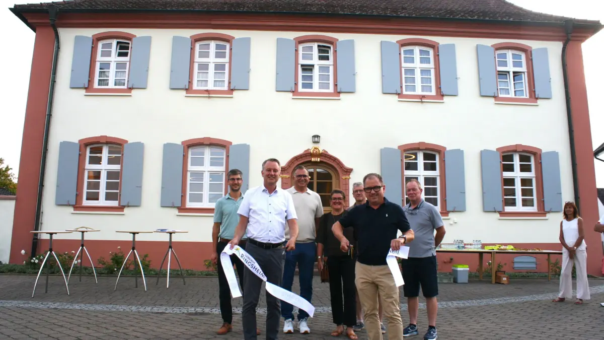 Mit einem symbolischen Bandschnitt durch Bürgermeister Pascal Weber (vorne links) und Architekt Bernd Billharz (rechts daneben) wurde das sanierte Pfarrhaus in Ringsheim eröffnet.