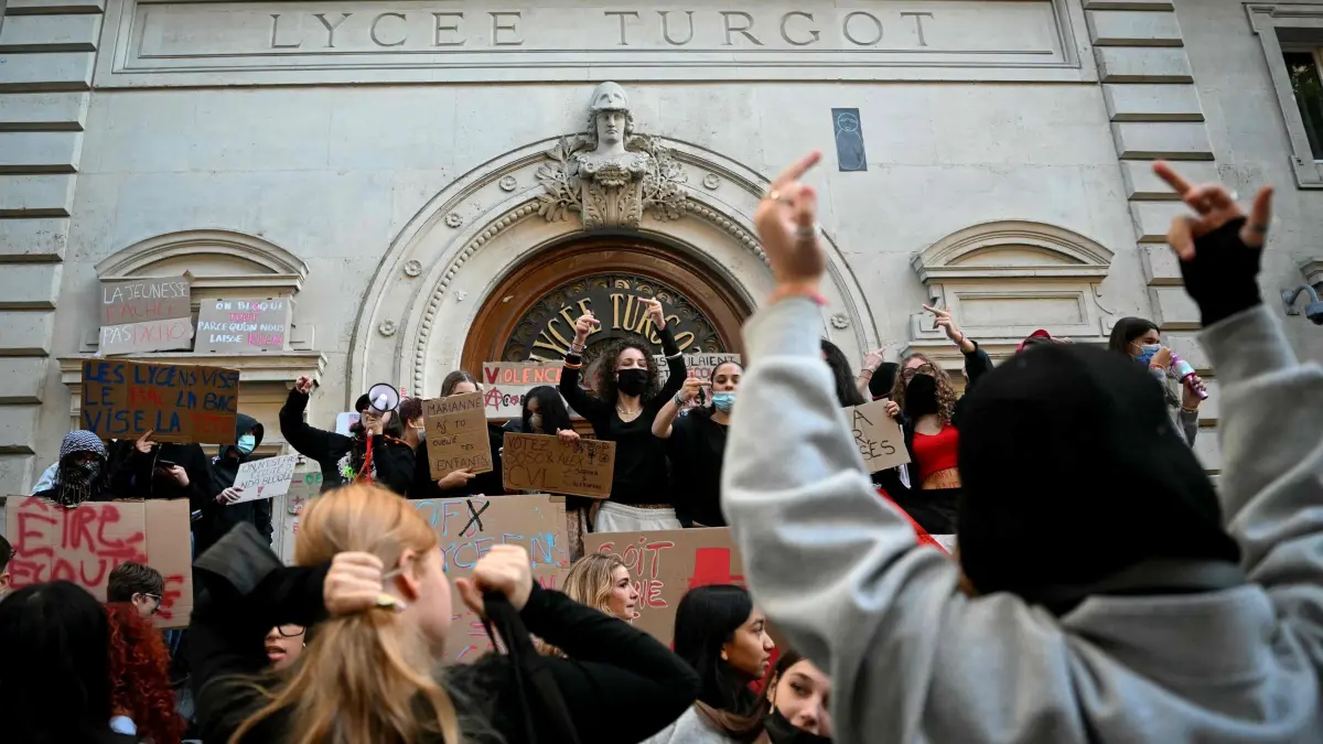 Schulproteste in Frankreich: Protestierende Schüler versammeln sich und halten Plakate hoch, während sie am 5. Oktober 2026 an der Turgot-Oberschule in Paris eine Blockadeaktion durchführen. Hunderte von Gymnasien werden am 5. Oktober 2026, am Vorabend eines neuen Mobilisierungstages, zu dem die Gewerkschaften zur Teilnahme aufrufen, erneut zumindest teilweise geschlossen, und während in den sozialen Medien Aufrufe zu einer harten Blockade zunehmen: Die Schüler fordern mehr Mittel für ihre Schulen und prangern den unhygienischen Zustand der Gebäude, überfüllte Klassen oder nicht ersetzte Lehrkräfte an, insbesondere in Arbeitervierteln, oder auch die durch Parcoursup verursachten Ungleichheiten. (Foto: LOU BENOIST / AFP) (zu dpa: «Schülerproteste in Frankreich gehen in zweite Woche»)