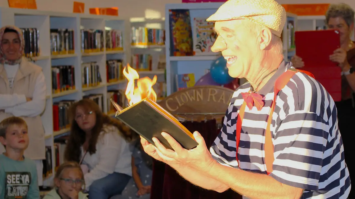 Entsprechend dem Motto Heiß auf Lesen loderten plötzlich Flammen aus dem Buch, das Zauberclown Rabe gerade lesen wollte.