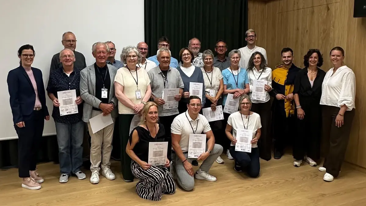 20 neue Stadtführer haben ihre Ausbildung erfolgreich abgeschlossen. Gemeinsam mit Finanz- und Bildungsbürgermeisterin Manuela Beck, den Verantwortlichen der WTG und weiteren Beteiligten stellten sie sich nach der Zertifikatsübergabe zum Erinnerungsfoto.