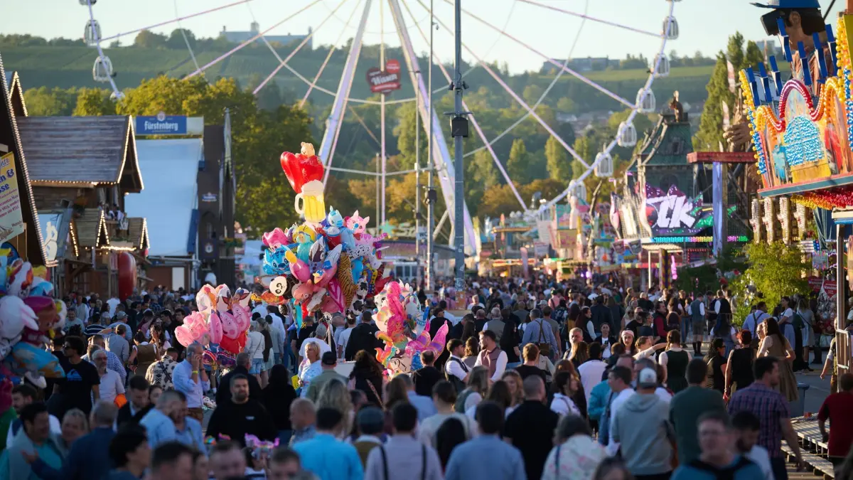Auftakt Cannstatter Volksfest: ARCHIV - 25.09.2026, Baden-Württemberg, Stuttgart: Besucher des Cannstatter Volksfestes gehen zwischen Buden und Fahrgeschäften. Das zweitgrößte Volksfest der Welt findet auf dem Festgelände auf dem Cannstatter Wasen bis zum 11. Oktober statt. (zu dpa: «Polizei geht nach Unfall an Fahrgeschäft von Unglück aus») Foto: Marijan Murat/dpa +++ dpa-Bildfunk +++