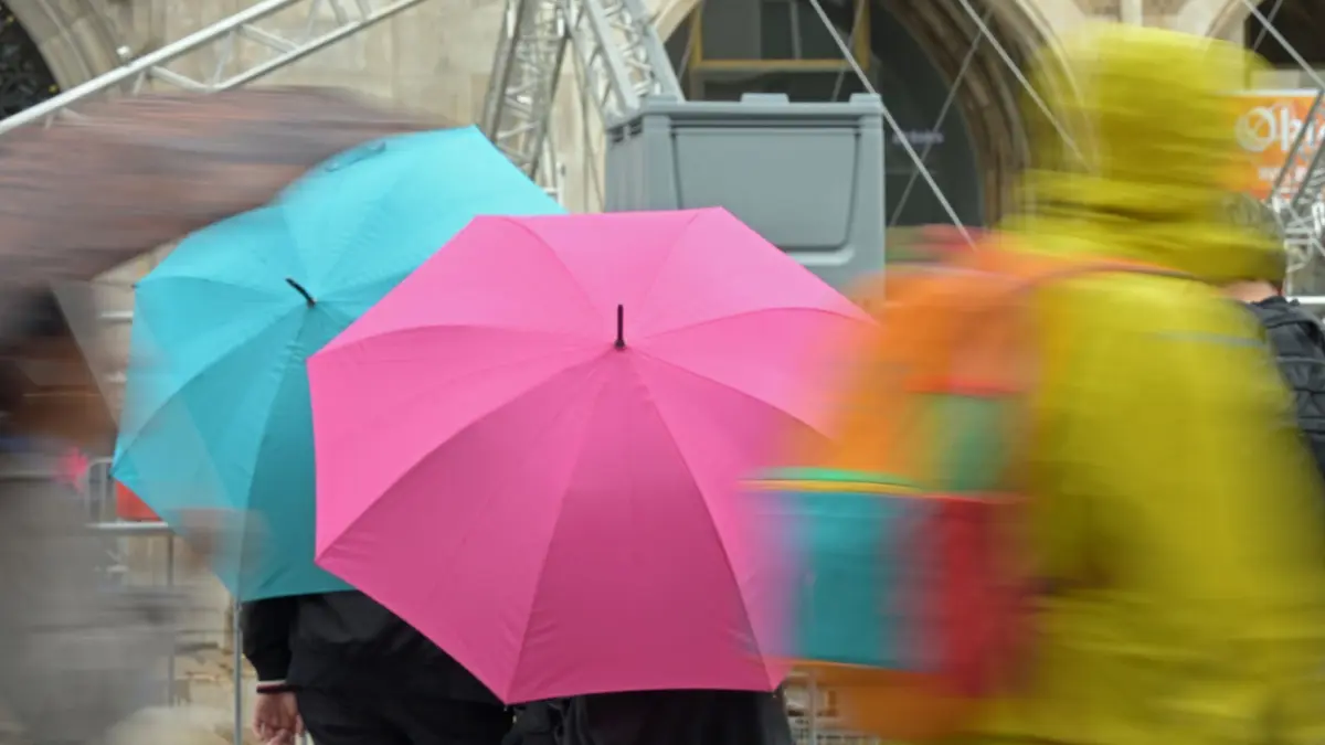 Regen in München - Wetter: Passanten gehen mit Regenschirmen durch die Altstadt. (zu dpa: «Der Samstag wird nass - der Sonntag etwas besser»)