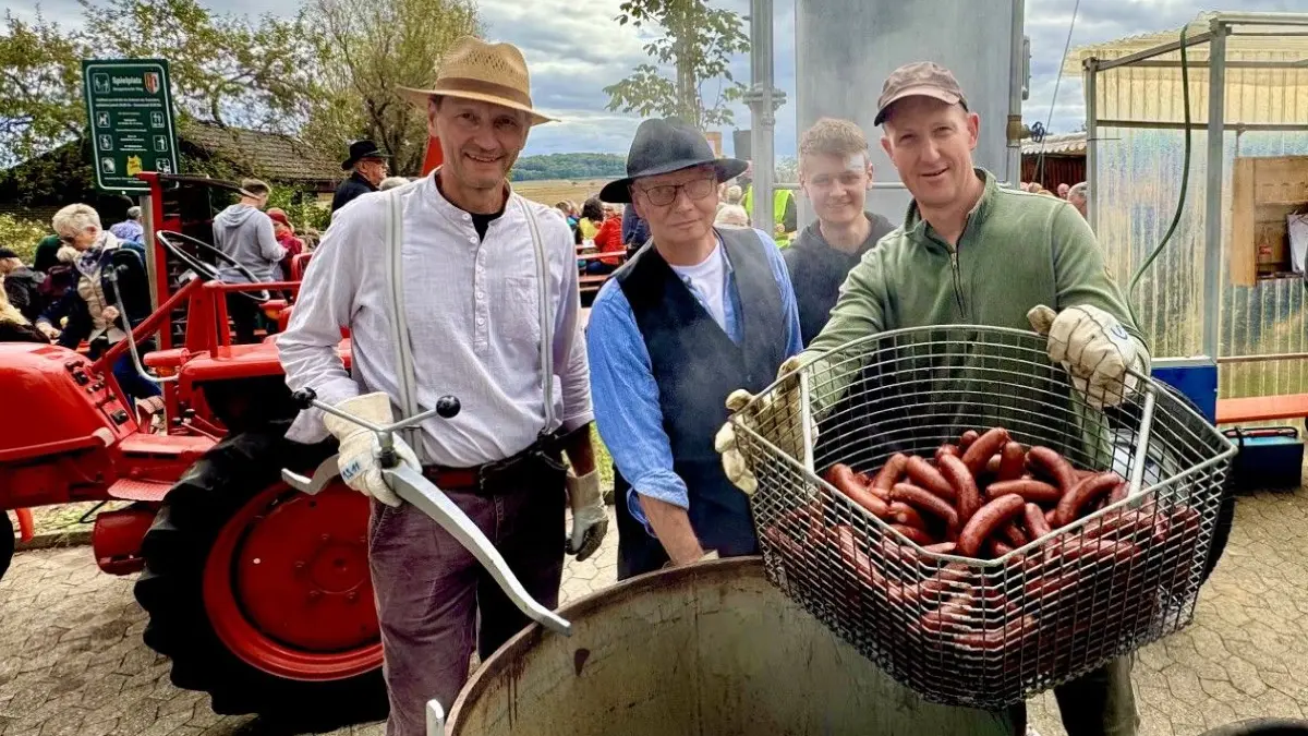 Marc Stöckle (von links), Uwe Breunig, Jonas Breunig und Gert Graser holen einen Korb mit Bauernwürsten aus der Dämpfi.