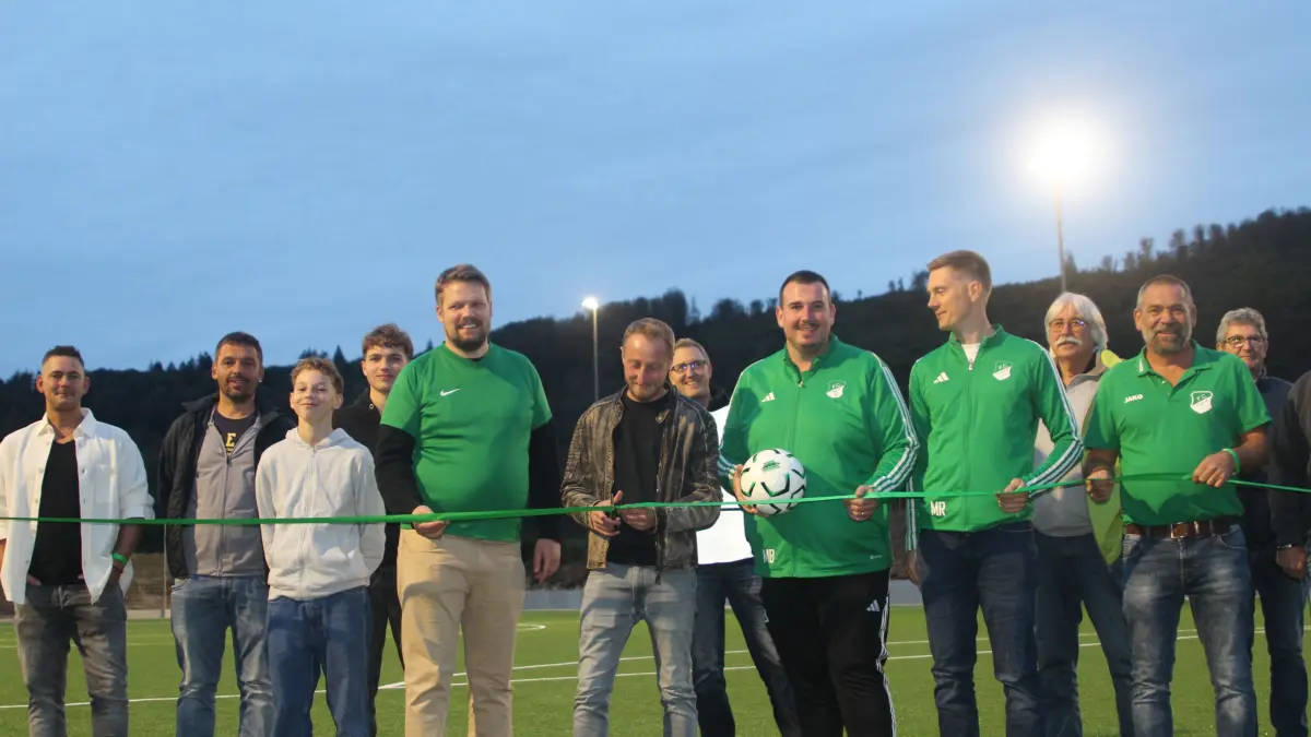 FC-Mitglieder, Bürgermeister Philipp Lotter und Gemeinderäte freuen sich, dass die Mannschaften des FC Hausen nun nicht mehr auf einem Hartplatz kicken müssen. Richard Wunderlich, Projektleiter des Bauteams, zerschneidet das Band bei der Einweihung.