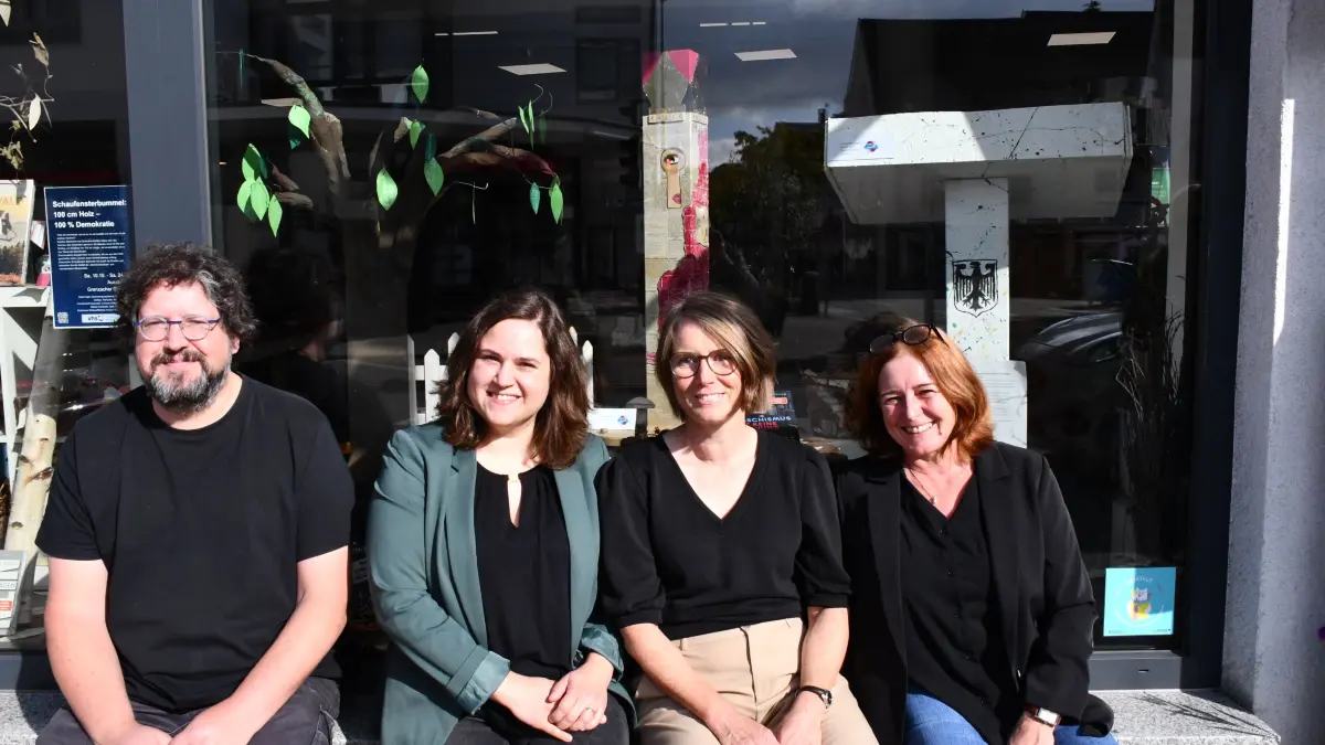 Christian Matthiä, Vanessa Gersbacher, Melanie Penninggers und Patricia Merkel (von links) vor der Buchhandlung Merkel, im Schaufenster die „Demokratiesäulen".