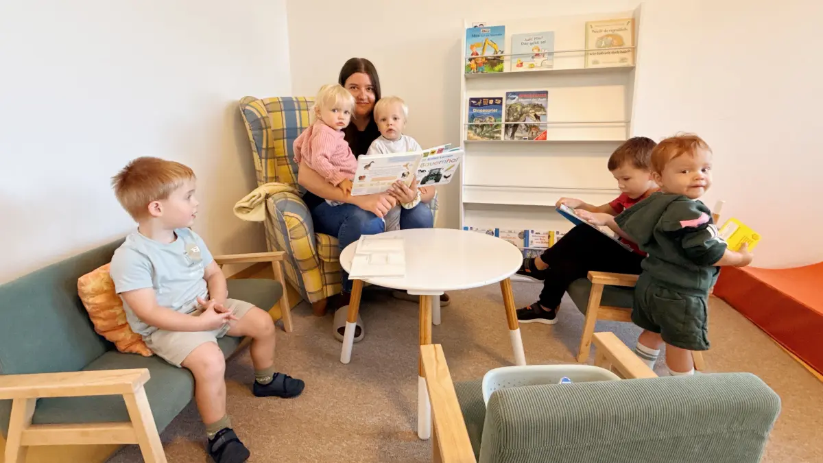 In der Leseecke haben es sich Kindergartenleiterin Marlen Wenzler und ein paar Kinder gemütlich gemacht.