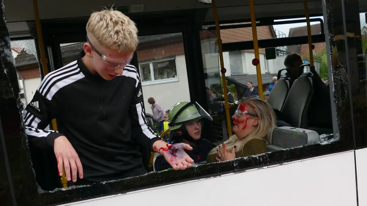 "Und wer versorgt meine Wunde?", ruft dieser Junge um Hilfe, während sich auf dem Sitz hinter ihm eine Einsatzkraft um eine verletzte Person kümmert.