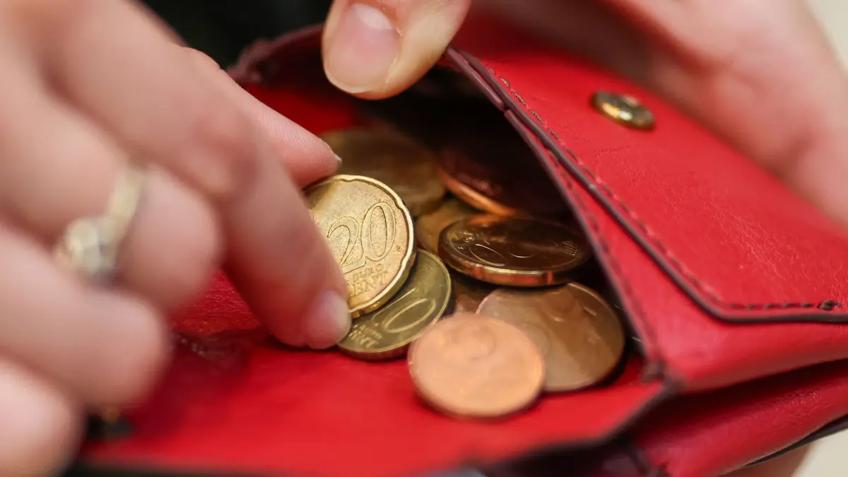 Armut in Sachsen-Anhalt: SYMBOLBILD - 12.03.2025, Sachsen, Leipzig: Eine Frau zählt Münzen aus einem roten Portemonnaie. (zu dpa: «Jeder Sechste in Sachsen-Anhalt ist armutsgefährdet») Foto: Jan Woitas/dpa +++ dpa-Bildfunk +++