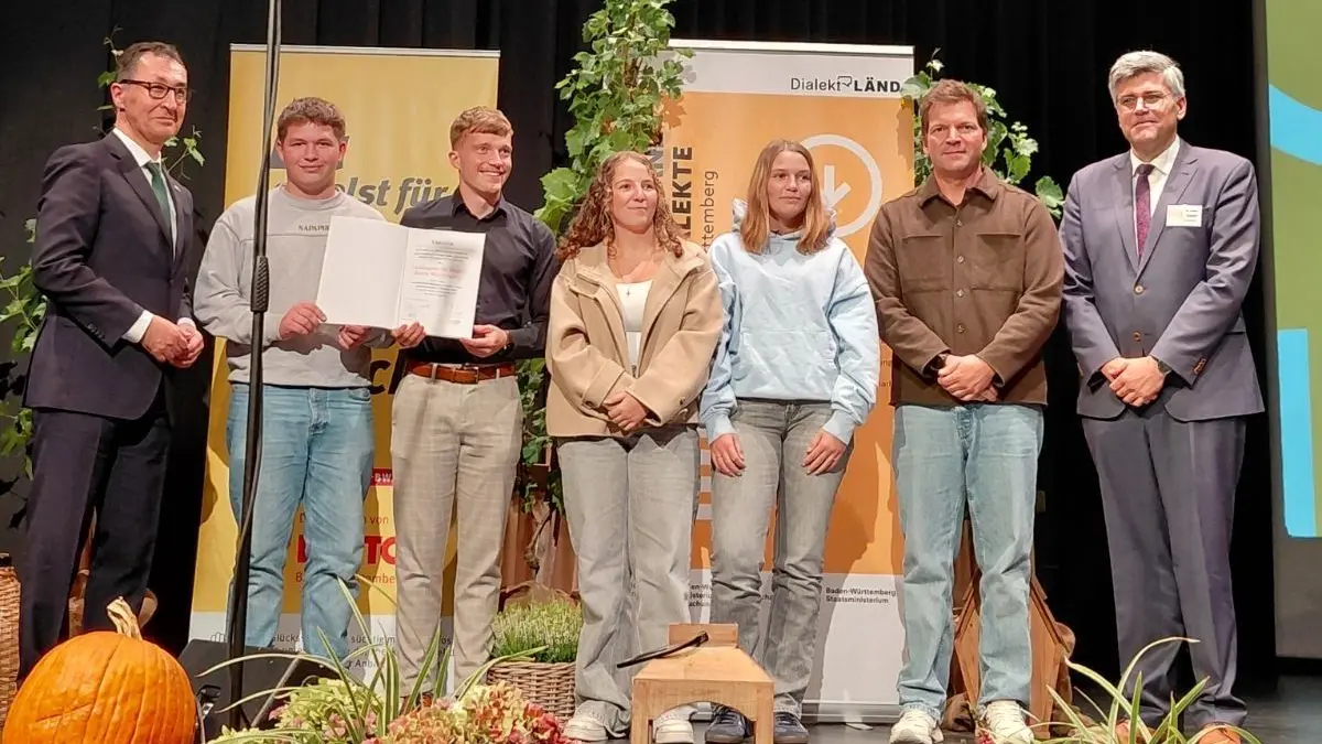 Ministerpräsident Cem Özdemir mit den Schülern Carlo Baldassare, Hannah Hanke und Lynn Schöne sowie Lehrer Marius Lais und Waldshuts Landrat Martin Kistler, Vorsitzender des Dachverbands der Dialekte Baden-Württemberg (von links). Die Schüler erhielten einen Anerkennungspreis in der Kategorie „Junge Generation“ für ihren Videobeitrag zu Gerhard Jungs Gedicht „2022“.