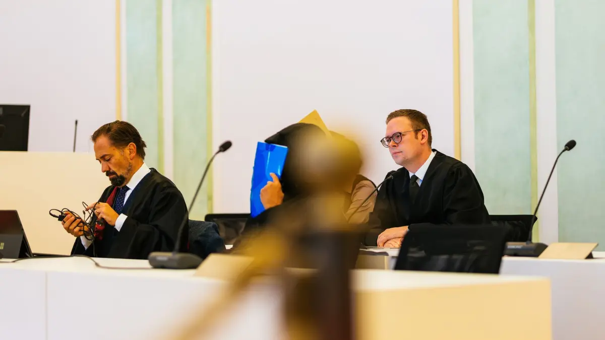 Beginn Prozess gegen Ehepaar u.a. wegen Störung der Totenruhe: Zwei Angeklagte sitzen zwischen ihren Verteidigern Nico Schmid (r) und Jan-Georg Wennekers (l). Einem angeklagten Ehepaar werden neben 50 Fällen von Diebstahl, beziehungsweise wegen Beihilfe, mindestens 250 Fälle vorgeworfen. Der Ehemann war nach Angaben des Gerichts bis Ende Oktober 2024 als Bestatter beim Eigenbetrieb Friedhöfe der Stadt Freiburg angestellt. Ihm wird vorgeworfen, von 2013 an Zahngold von Leichen entwendet zu haben, die verbrannt werden sollten - teilweise mit grober Gewalt. Außerdem soll er den Leichen Schmuck, Uhren und sonstige Wertgegenstände abgenommen haben. Seine Frau soll ihn bei den Taten unterstützt haben. (zu dpa: ««Besonders grotesk» - Bestatter plünderte jahrelang Tote»)