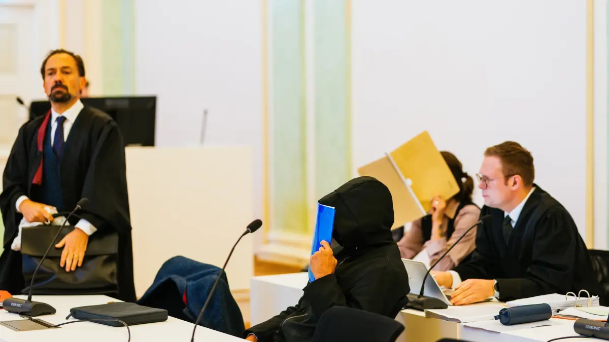 Beginn Prozess gegen Ehepaar u.a. wegen Störung der Totenruhe: Zwei Angeklagte sitzen zwischen ihren Verteidigern Nico Schmid (r) und Jan-Georg Wennekers (l). Einem angeklagten Ehepaar werden neben 50 Fällen von Diebstahl, beziehungsweise wegen Beihilfe, mindestens 250 Fälle vorgeworfen. Der Ehemann war nach Angaben des Gerichts bis Ende Oktober 2024 als Bestatter beim Eigenbetrieb Friedhöfe der Stadt Freiburg angestellt. Ihm wird vorgeworfen, von 2013 an Zahngold von Leichen entwendet zu haben, die verbrannt werden sollten - teilweise mit grober Gewalt. Außerdem soll er den Leichen Schmuck, Uhren und sonstige Wertgegenstände abgenommen haben. Seine Frau soll ihn bei den Taten unterstützt haben. (zu dpa: «Zahngold von Toten geklaut? Bestatter droht Haftstrafe»)