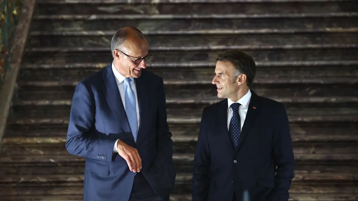 Merz und Macron: Bundeskanzler Friedrich Merz (l, CDU) und Emmanuel Macron, Präsident von Frankreich, kommen zu einer Pressekonferenz nach einem Treffen des Deutsch-Französischen Ministerrats im Rahmen von Regierungskonsultationen beider Länder auf Schloss Augustusburg. (zu dpa: «Deutschland und Frankreich vor Einigung bei Verbrenner-Aus»)