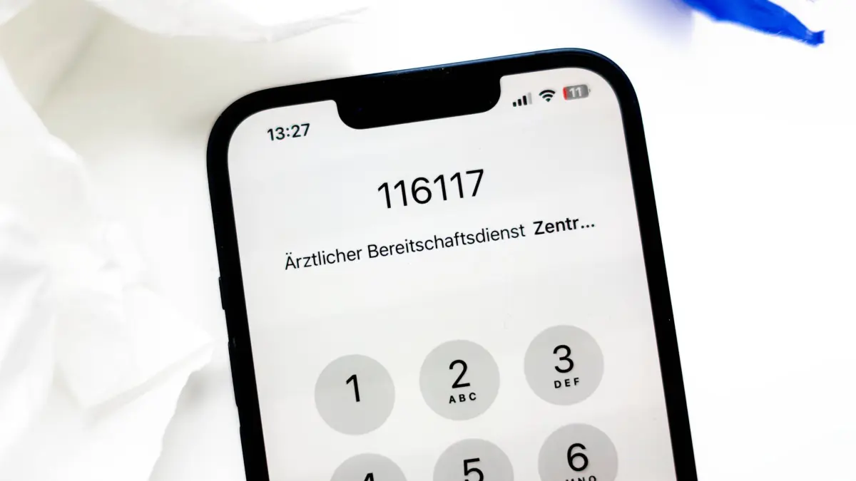 Nummer des Ärztlichen Bereitschaftsdienstes auf einem Smartphone: Beim Patientenservice 116117 kann man die Beschwerden schildern und bekommt eine Ersteinschätzung. Dort wird man auch an Bereitschaftsärzte vermittelt. (zu dpa: «Notfallreform: Was gilt aktuell bei Krankheit und Unfall?»)