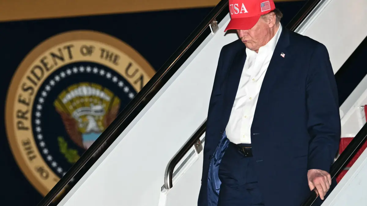 US-POLITICS-TRUMP: US President Donald Trump disembarks Air Force One at Joint Base Andrews, Maryland in the early hours of October 15, 2026. President Trump is returning to the White House after a two-day trip where he held campaign rallies in Alaska, Arizona and Montana, ahead of the midterm elections. (Photo by Kent NISHIMURA / AFP)