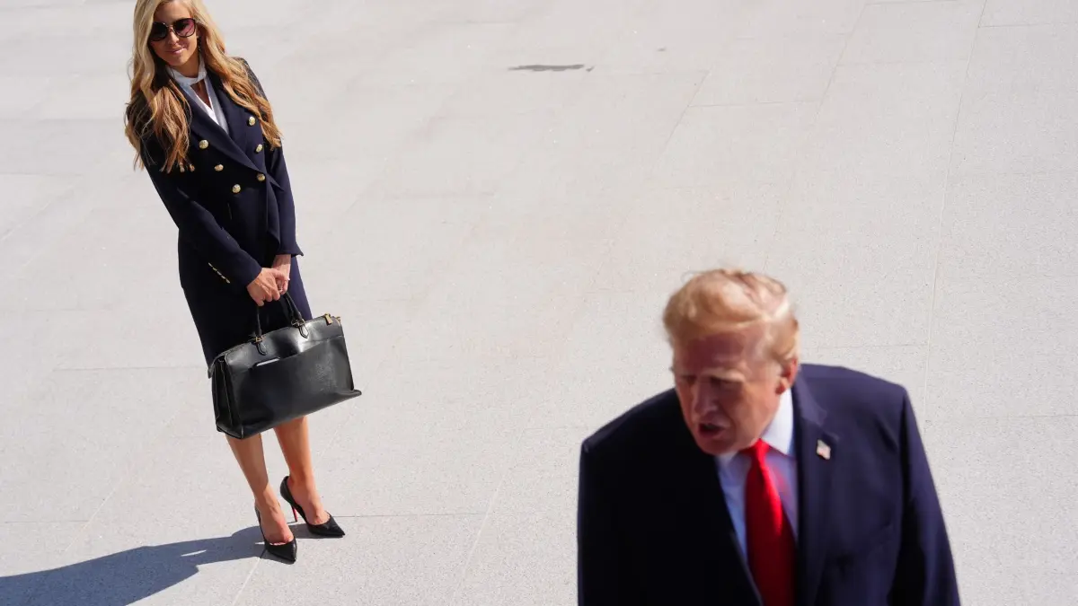 Pressesprecherin des Weißen Hauses Zacharia: US-Präsident Donald Trump spricht auf dem South Lawn des Weißen Hauses mit Reportern, bevor er an Bord der «Marine One» geht. Die Pressesprecherin des Weißen Hauses, Katie Zacharia, beobachtet die Szene. (zu dpa: «Trump öffnet Tür für Rücktritt seiner neuen Sprecherin»)