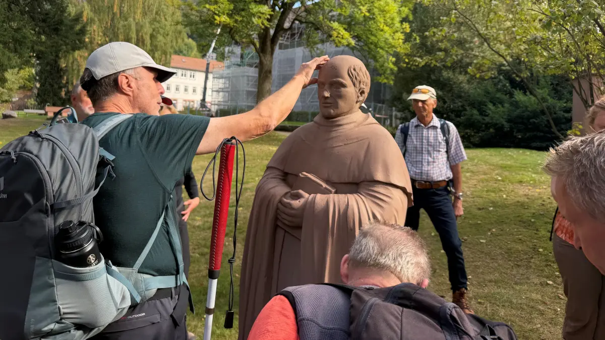 Die Teilnehmer ertasten und fühlen den Steinernen Mönch im Herrenalber Klosterareal.