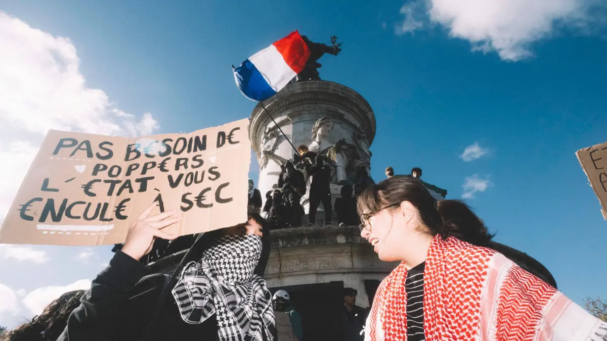 Protesttag in Frankreich: 17.10.2026, Frankreich, Paris: Demonstranten halten auf dem Place de la République in Paris Plakate hoch, auf einem steht: „Pas besoin de poppers, l’État vous encule a sec“ («Keine Poppers nötig, der Staat fickt euch trocken»). Foto: Fabian Suspensivo/ZUMA Press Wire/dpa +++ dpa-Bildfunk +++