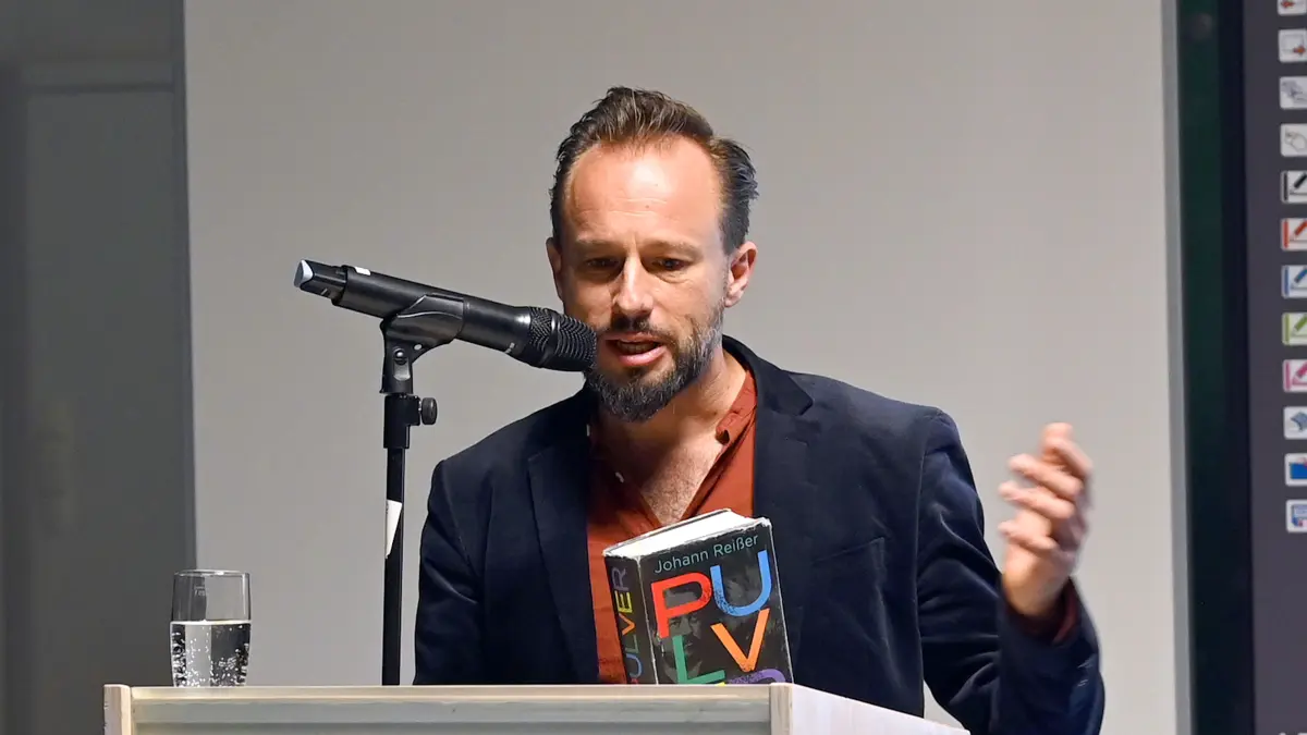 Johann Reißer liest am 16.10.2026 in Oberndorf aus seinem Roman "Pulver", der unter anderem die Geschichte von Max Duttenhofer erzählt. Veranstaltungsort ist der "Schwedenbau", eine frühere Mauser-Fabrik, ein Geschichtsort, in dem jetzt Gschichte erzählt werde, wie die einladende Leiterin der Satdtbücherei, Verena Jaburg, den rund 100 Besuchern ins Gedächtnis ruft.