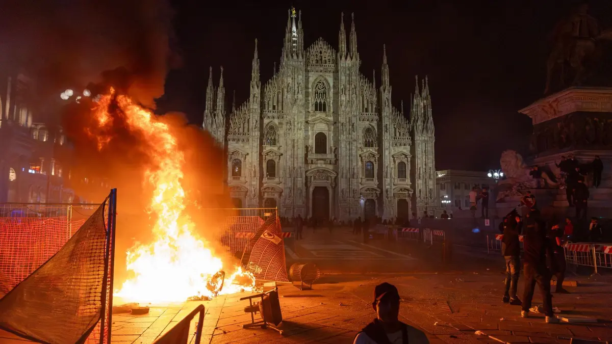 Proteste in Italien: Nach Zusammenstößen zwischen der Polizei und Demonstranten der Bewegung „Italia in Piazza“ vor dem Mailänder Dom brennt ein Feuer. (zu dpa: «Auch in Italien gewalttätige Proteste»)
