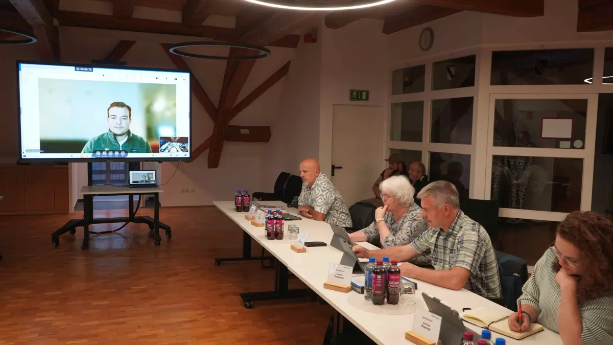 Bei der Beratung zum Thema Agri-PV für Urach war der Projektentwickler Maximilian Tettenborn von der Feldwerke GmbH aus München per Video in den Bürgersaal zugeschaltet und stand den Gemeinderäten Rede und Antwort. In der Bildmitte Ortsvorsteher Markus Dannecker, der auch die Bedenken des Ortschaftsrates und der Bürger deutlich formulierte.