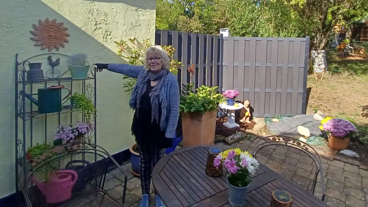Ute Mayer auf der Terrasse ihrer Doppelhaushälfte: Hinter dieser Wand befinden sich die maroden Abwasserrohre.