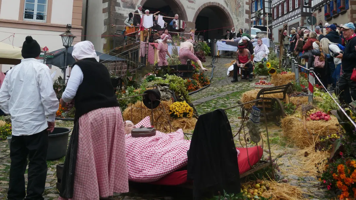 Wimmelbild mit Badern, der Schiltacher Marktplatz mit dem Rathaus