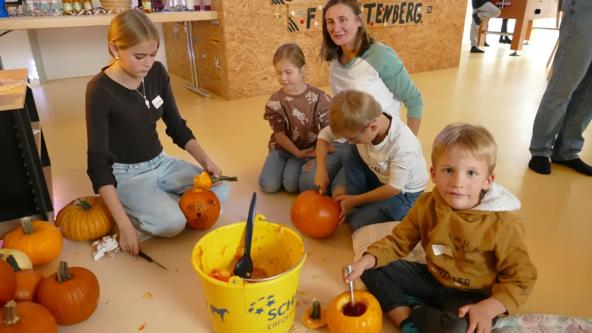 Haben viel Spaß im Jugendraum: Jung und Alt bringen beim Kürbisschnitzen ihre Ideen ein.