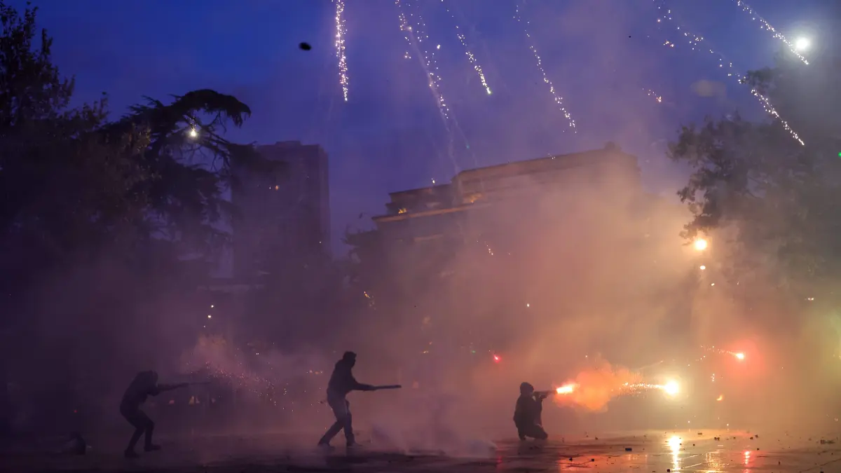 ALBANIA-POLITICS-EDUCATION-DEMO: Protesters use fireworks as they clash with riot police during a national anti-government demonstration - called by the student-led protest movement to demand better support for education and prime minister's resignation, in central Tirana on October 24, 2026. (Photo by Adnan Beci / AFP)